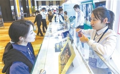 在北京麗澤商務(wù)區(qū)，工作人員（右一）介紹數(shù)字人民幣SIM卡硬錢包。新京報記者 陶冉攝