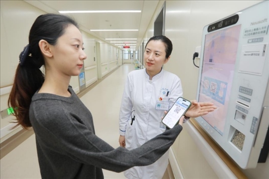 醫(yī)護(hù)人員引導(dǎo)患者在自助機(jī)前辦理自助入院手續(xù)。圖片來源：山東第一醫(yī)科大學(xué)第二附屬醫(yī)院