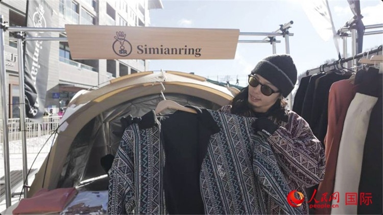 藤田周正在展示自己設(shè)計(jì)的滑雪服。人民網(wǎng)記者 袁蒙攝