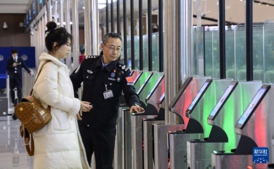 1月2日，大興機(jī)場(chǎng)邊檢站警察指導(dǎo)旅客使用自助出境設(shè)備。新華社記者 李欣 攝