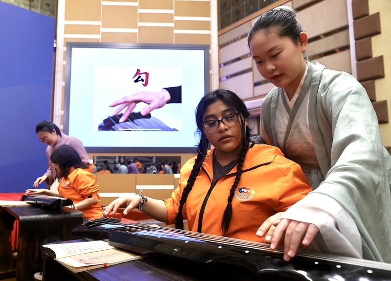 2024年3月20日，美國(guó)華盛頓州中學(xué)生代表團(tuán)北京大學(xué)交流活動(dòng)在北京大學(xué)英杰交流中心舉行。圖為來(lái)自華盛頓州的中學(xué)生體驗(yàn)古琴。