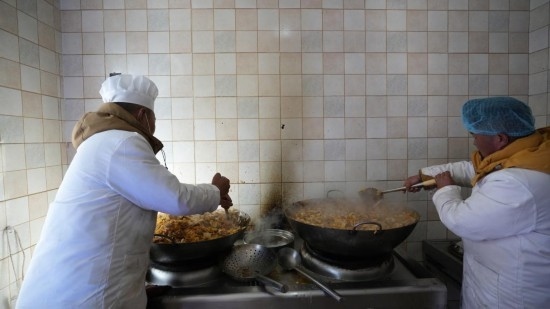 1月14日，服務(wù)隊的兩名廚師正在為村民們做午飯。新華社記者 邱星翔 攝