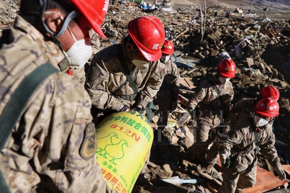 1月10日，定日縣長所鄉(xiāng)古榮村，武警官兵幫助受災群眾整理廢墟，搶救被掩埋的物資。環(huán)球時報記者崔萌攝