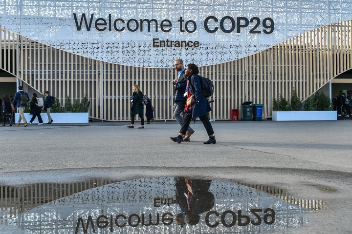 2024年11月15日，在阿塞拜疆首都巴庫(kù)，人們經(jīng)過聯(lián)合國(guó)氣候變化巴庫(kù)大會(huì)的會(huì)場(chǎng)。新華社記者 曹陽(yáng) 攝