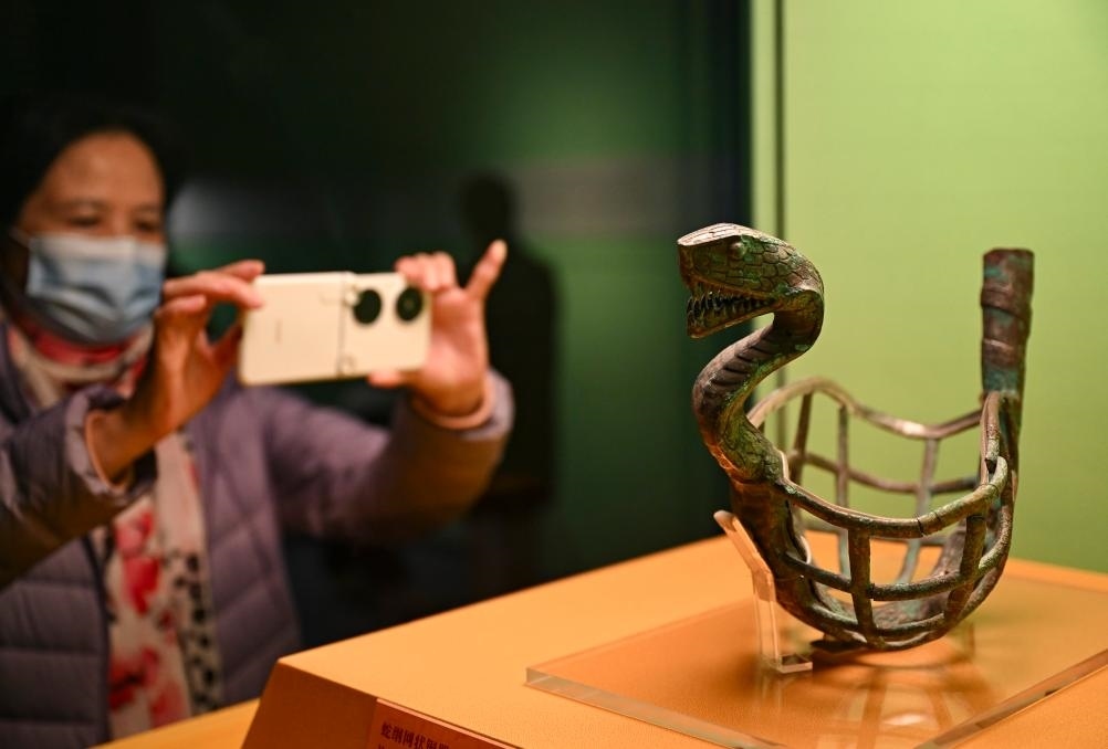 1月14日，觀眾在上海博物館蛇年迎春展拍攝展品蛇綱網(wǎng)狀銅器。新華社發(fā)（陳浩明攝）