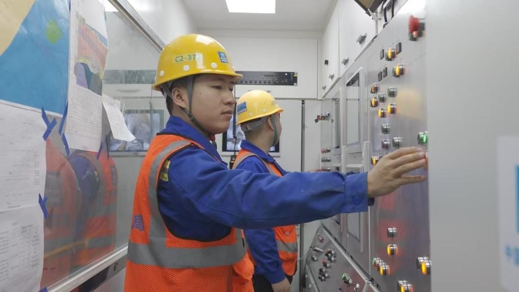 盾構(gòu)司機(jī)何曉波在駕駛室內(nèi)調(diào)試盾構(gòu)機(jī)參數(shù)。（劉芬攝）