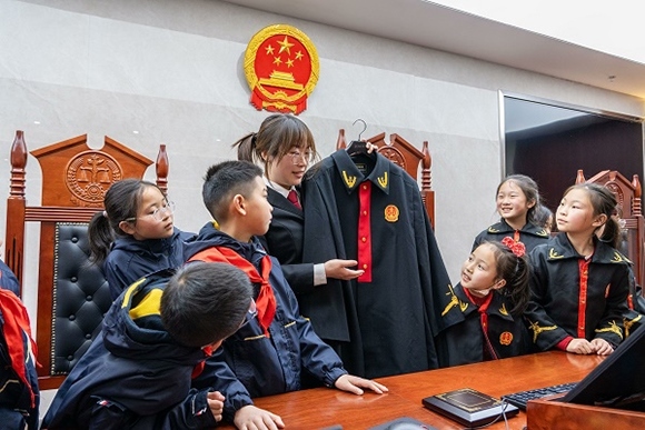 圖②：干警向同學們介紹法袍。