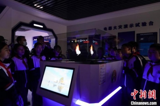 圖為學(xué)生們參觀道里區(qū)消防救援大隊消防科普體驗館內(nèi)幻影成像燃燒三要素實驗臺。中新社記者 趙宇航 攝