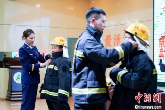 圖為學(xué)生們現(xiàn)場穿戴消防頭盔和戰(zhàn)斗服。中新社記者 趙宇航 攝