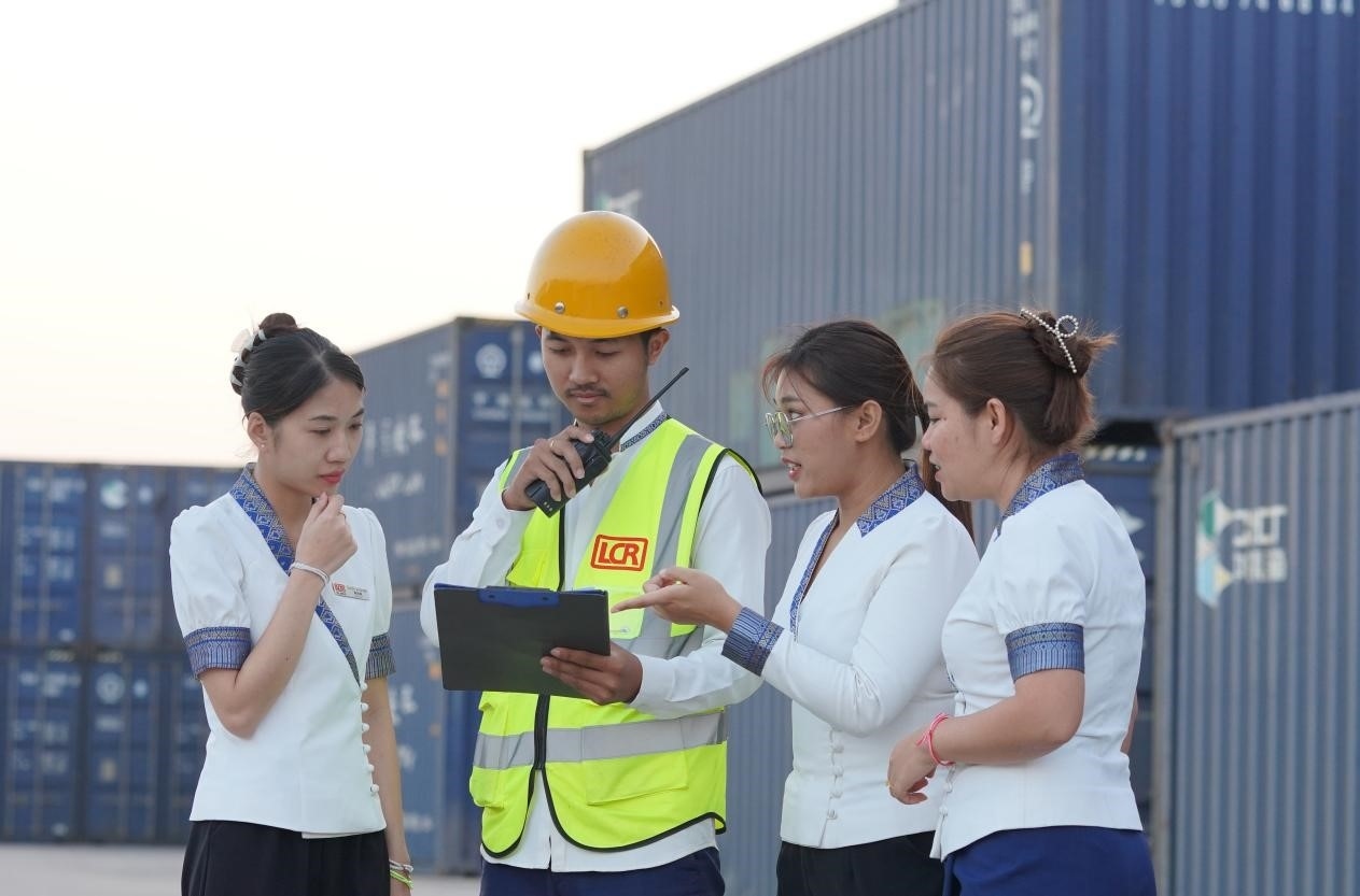 萬(wàn)象南站貨運(yùn)值班員陳尼啦（左一）與同事在一起討論工作。老中鐵路有限公司供圖