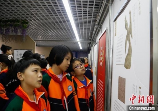 圖為學生參觀青海省博物館“1+3”主題流動展覽，了解木舞俑。中新社記者 馬銘言 攝