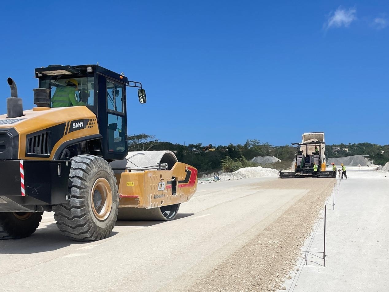 圖為中企承建的牙買加蒙特哥貝繞城路項(xiàng)目基層試驗(yàn)段正在進(jìn)行攤鋪和碾壓施工，相關(guān)施工工作已于日前順利完成。中國(guó)港灣美洲區(qū)域公司供圖