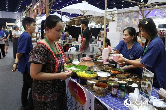 游客在攤位前購(gòu)買特色美食。朱瀟逸攝