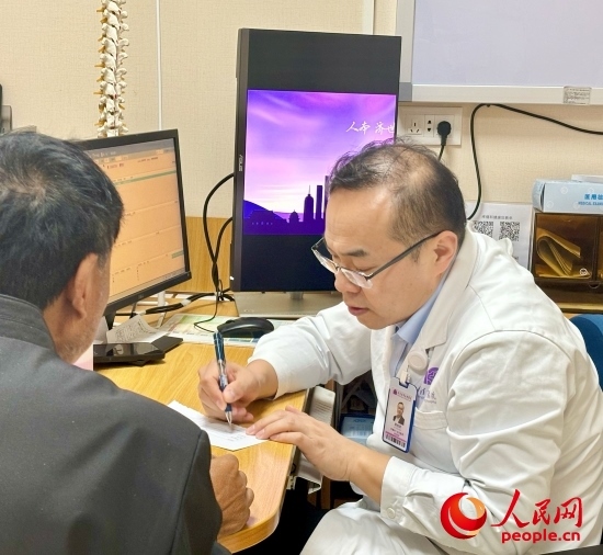 路桂軍接診時為患者寫下用藥提示。人民網(wǎng)記者 金慧慧攝