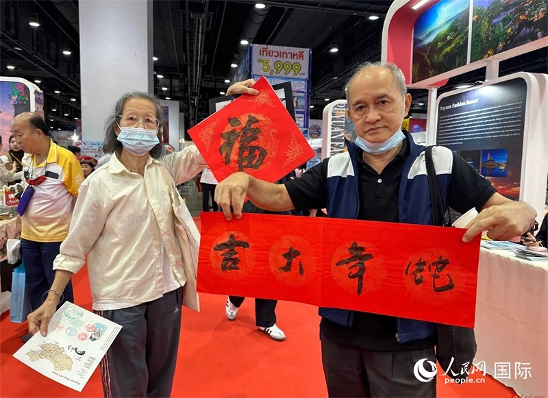 2025蛇年春節(jié)，泰國市民展示他們領(lǐng)到的華人手寫春聯(lián)。人民網(wǎng)記者 簡承淵攝