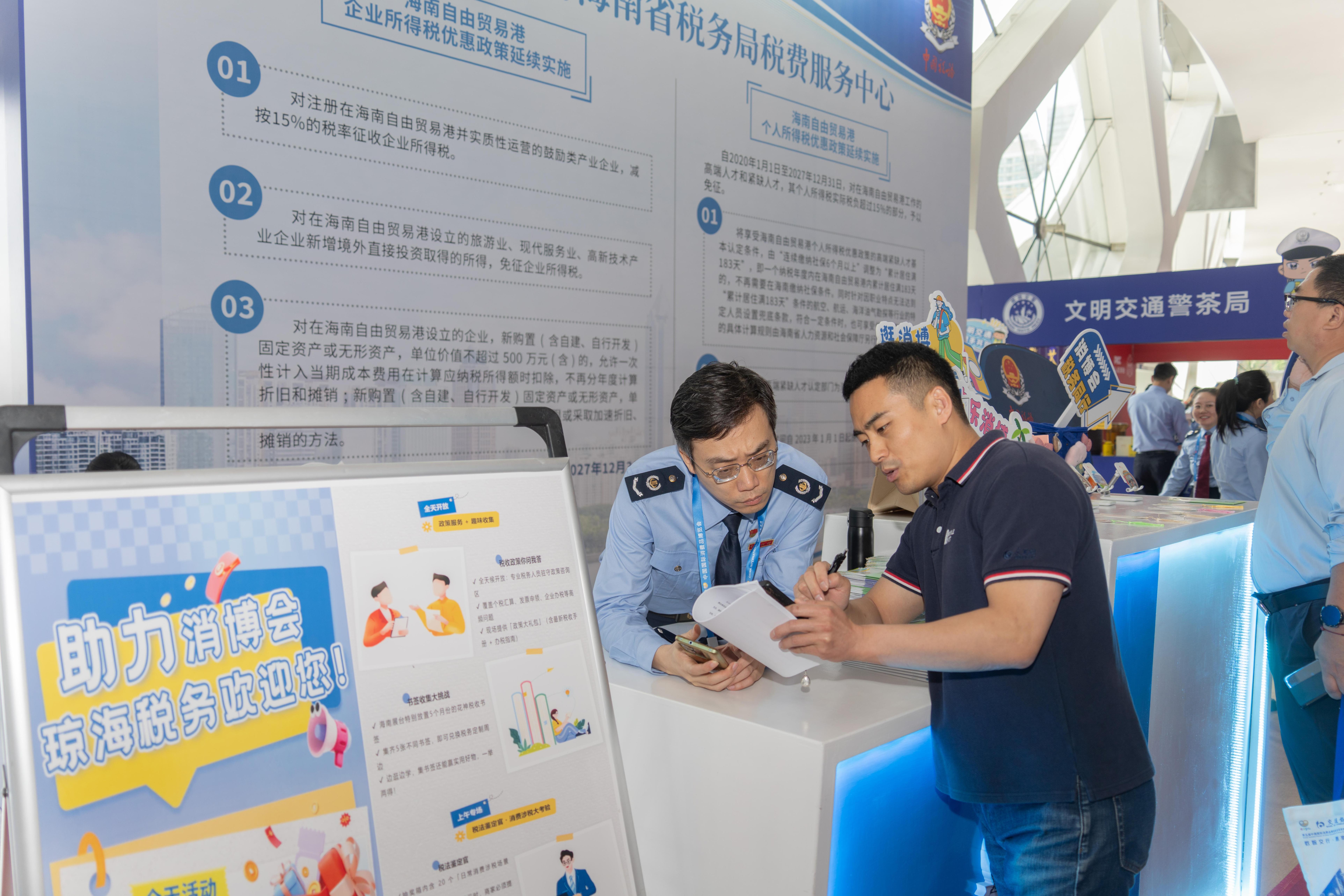 稅務(wù)服務(wù)臺工作人員向記者介紹服務(wù)參展外商的具體舉措。人民網(wǎng)記者 許崢攝