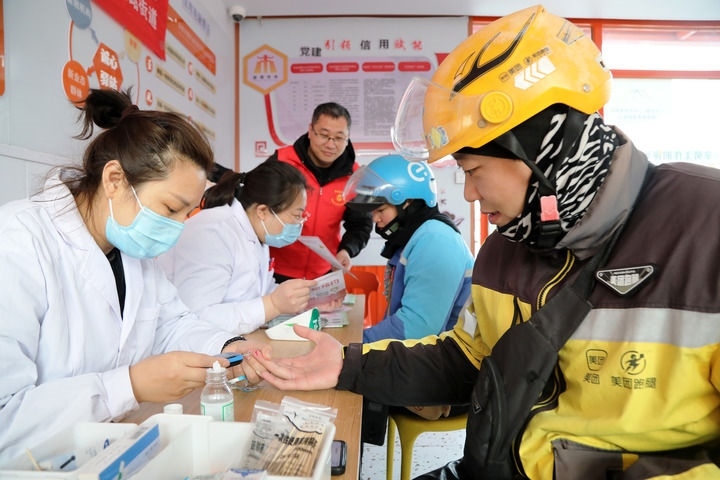 2025年3月5日，志愿者在山東省棗莊市市中區(qū)一工會驛站為外賣員免費(fèi)測量血糖。新華社發(fā)（王海楠攝）