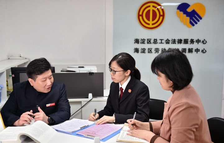 2025年3月6日，在北京市海淀區(qū)總工會勞動(dòng)爭議調(diào)解中心，海淀區(qū)人民法院法官王琰（中）與該中心工作人員就糾紛化解情況進(jìn)行溝通。新華社記者 趙婷婷 攝