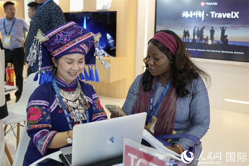 來自廣西的旅游業(yè)者同客戶交流。人民網(wǎng)塔里克·易卜拉欣攝
