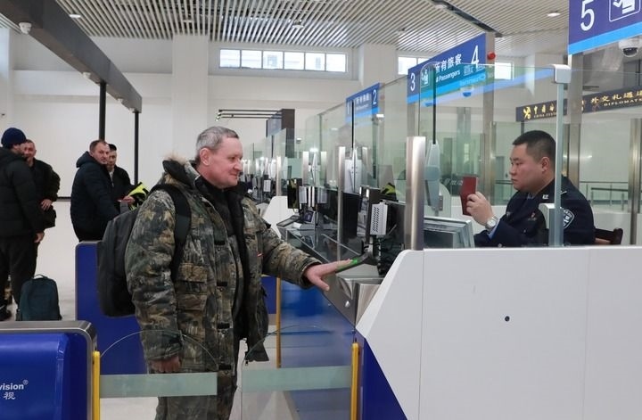 2024年12月10日，在黑河公路口岸旅檢大廳，黑河出入境邊防檢查站民警為首班次客車入境旅客辦理邊檢通關(guān)手續(xù)。當(dāng)日，中國黑河公路口岸—俄羅斯卡尼庫爾干公路口岸旅客運(yùn)輸正式開通。新華社發(fā)（劉松攝）