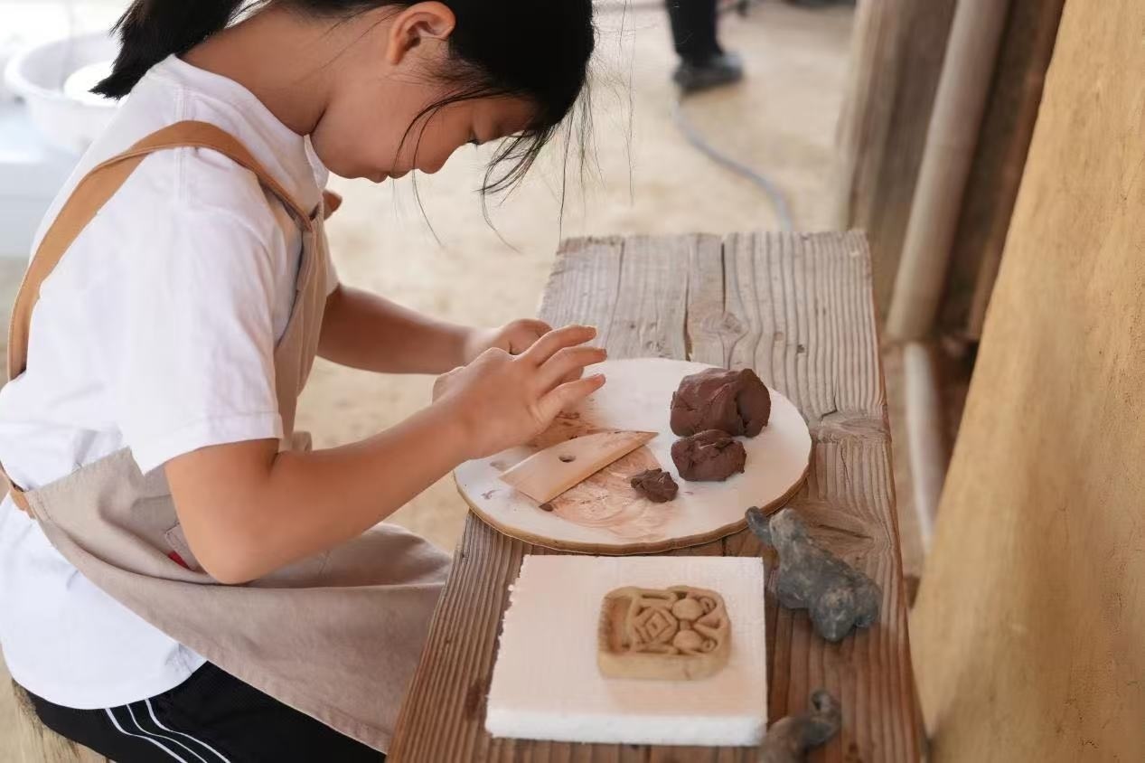 游客制作良渚特色陶藝品。良渚博物院供圖