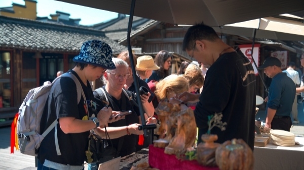 “五一”期間，游客正在烏鎮(zhèn)“水鄉(xiāng)碼頭”挑選購(gòu)買(mǎi)文創(chuàng)產(chǎn)品。受訪(fǎng)者供圖