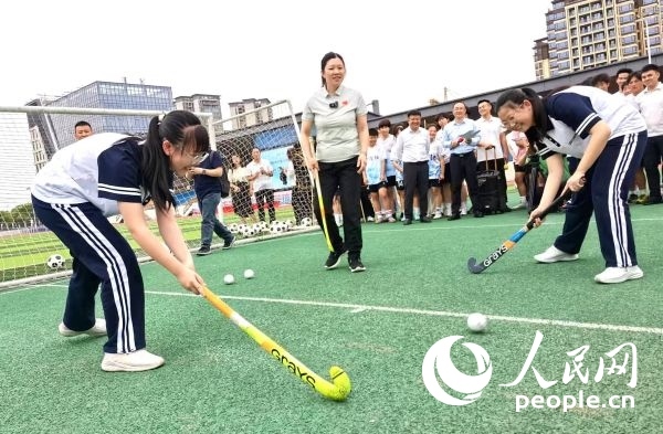 陳朝霞（中）指導(dǎo)學(xué)生體驗(yàn)曲棍球。 人民網(wǎng)記者 楊磊攝
