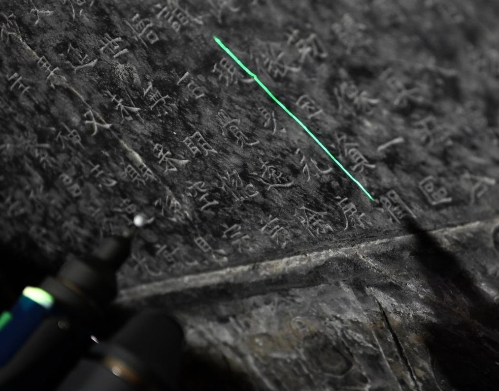 2025年4月9日，龍門(mén)石窟研究院工作人員在古陽(yáng)洞使用關(guān)節(jié)臂掃描儀對(duì)《龍門(mén)二十品》之一進(jìn)行數(shù)字化掃描。新華社記者 李嘉南 攝