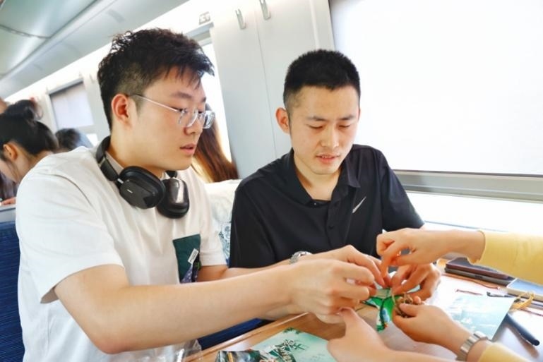 G232次旅客親手制作端午荷包和五彩繩。王磊攝