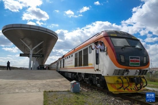 5月31日，在蒙內(nèi)鐵路內(nèi)羅畢站，機車駕駛員蔣立平（右）和博爾在即將開往蒙巴薩的E2次列車上揮手致意。新華社記者 楊光 攝