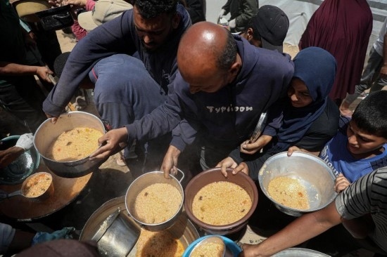 5月28日，人們?cè)诩由吵俏鞑康纳程犭y民營(yíng)領(lǐng)取救助食物。新華社發(fā)（里澤克·阿卜杜勒賈瓦德攝）