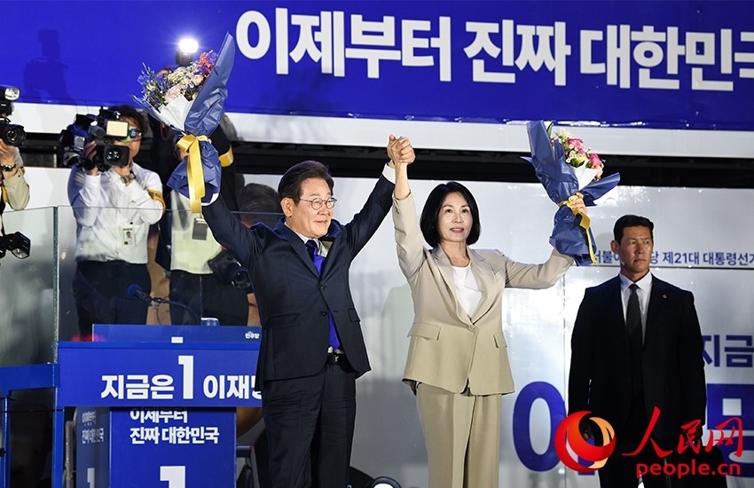 6月4日凌晨，確定當(dāng)選韓國(guó)總統(tǒng)的李在明舉手向歡呼的支持者們致意。 人民網(wǎng) 康炯彬攝